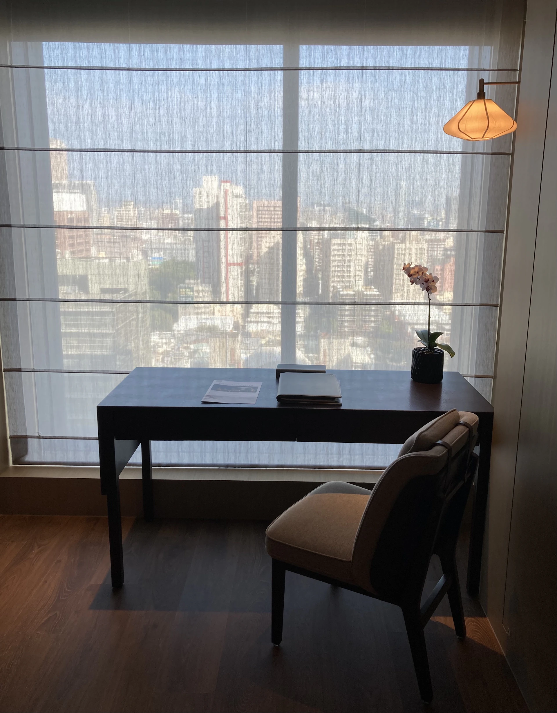 a desk and chair in a room with a large window