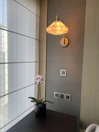 Softly lit room corner featuring a decorative lamp and a vase of fresh flowers.