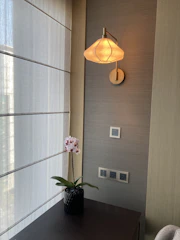 Softly lit room corner featuring a decorative lamp and a vase of fresh flowers.