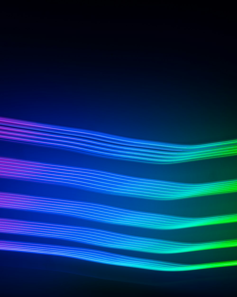 a black background with a multicolored wave of light