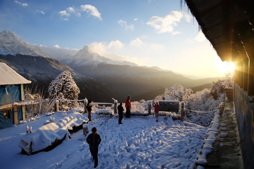 a group of people standing on top of a snow covered slope