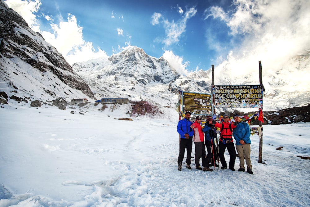 a group of people standing on top of a snow covered slope