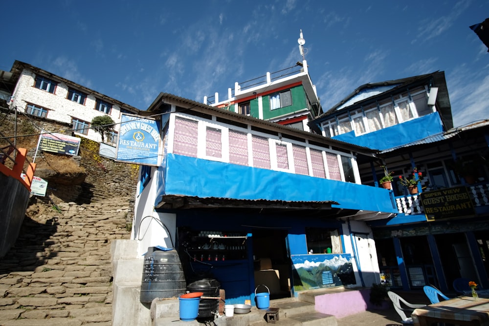 a building with a blue awning next to a stone walkway