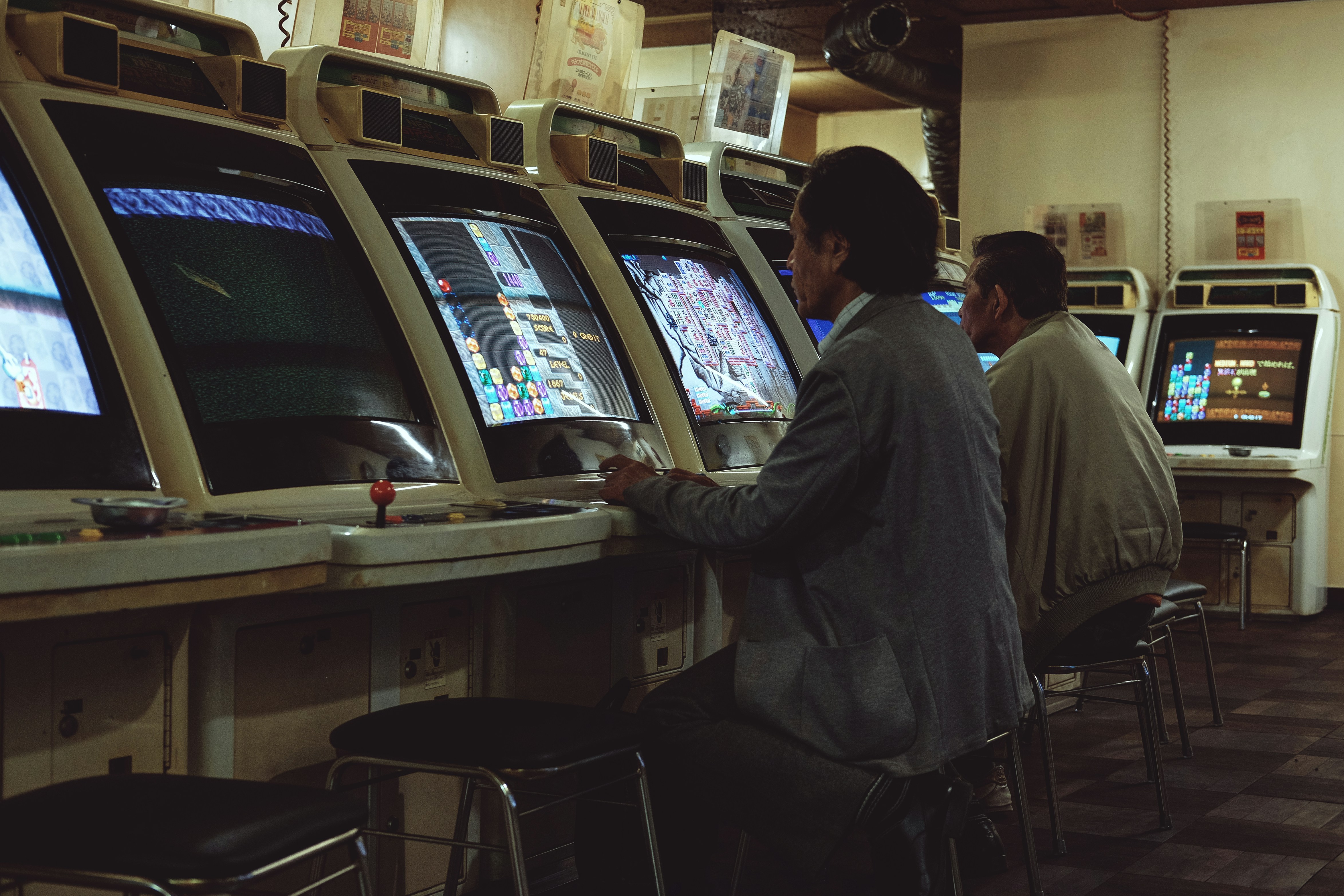 a man playing a video game in front of a row of slot machines