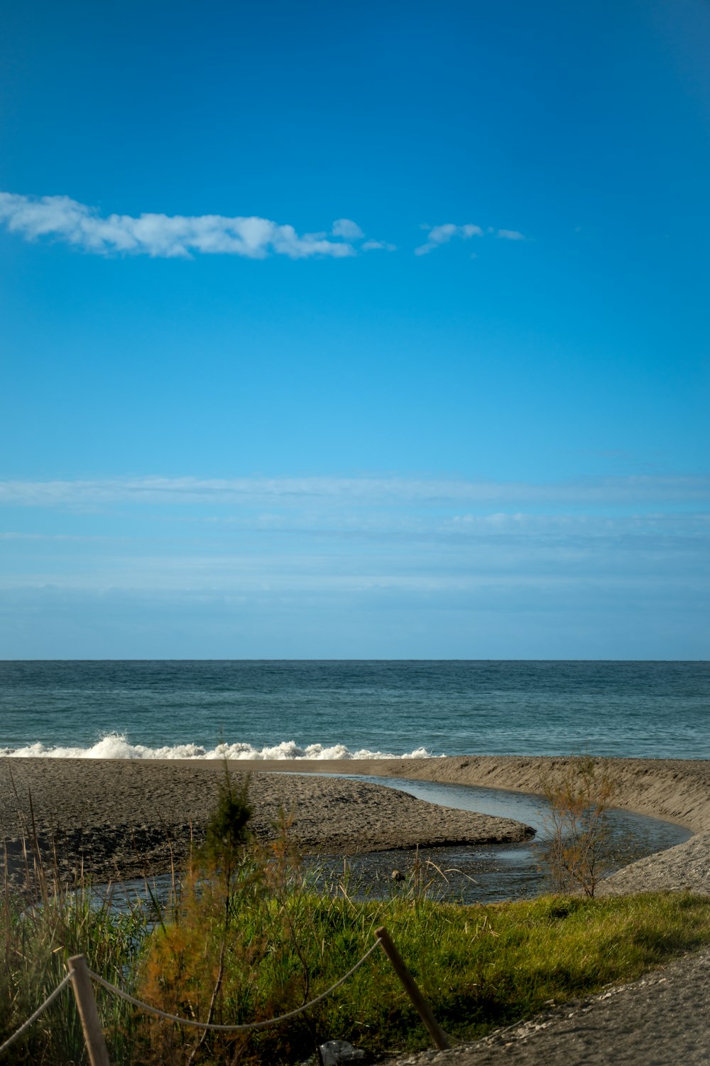 a body of water sitting next to a sandy beach