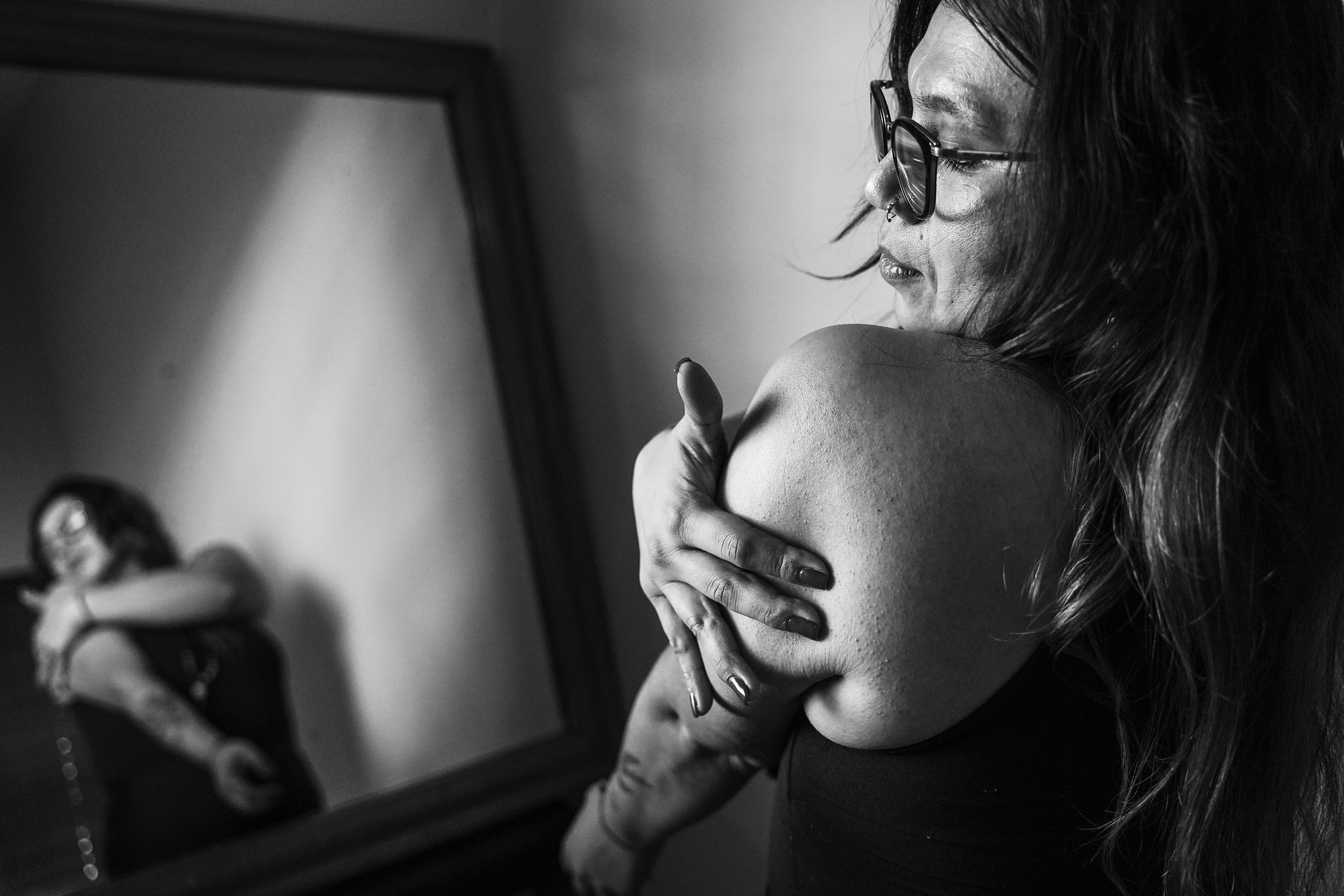 a woman holding her arm in front of a mirror