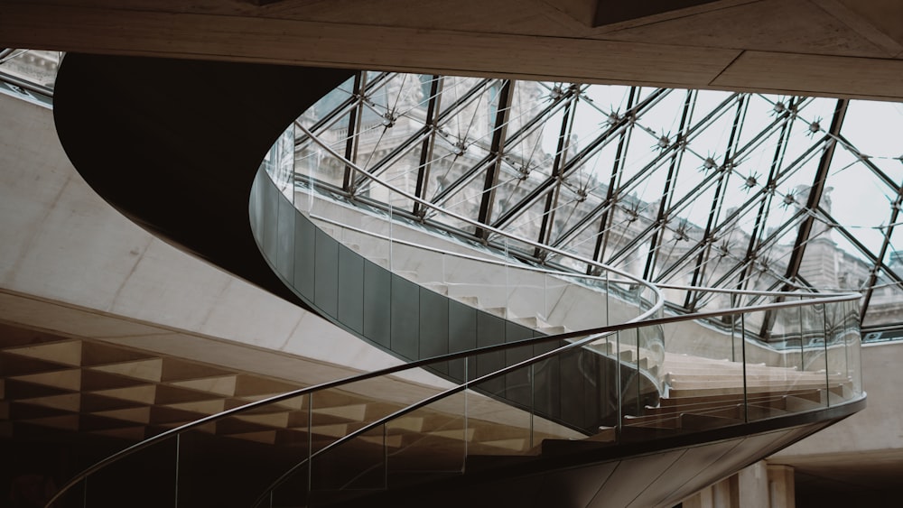 a spiral staircase in a building with a glass roof