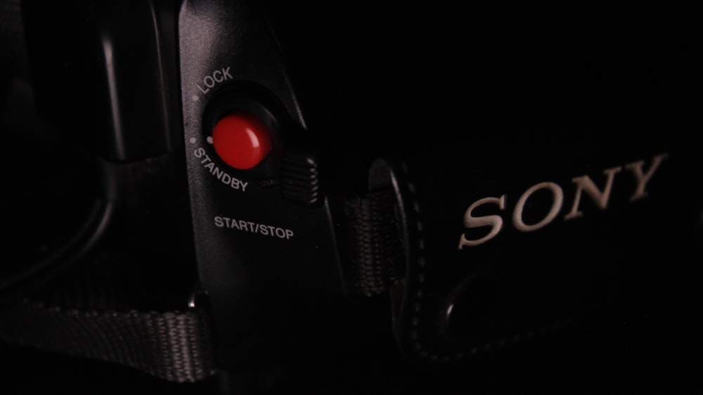 a black sony camera with a red lens