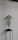 A wire sculpture of a human torso is displayed on a minimalist black stand. The sculpture has a hollow, mesh-like structure, showcasing the contours of a female torso without arms or a head. It is set against a plain, light-colored wall, creating a stark contrast.
