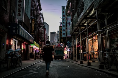 An urban explorer crossing a graffiti-covered alleyway under flickering neon signs.