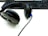 A pair of black over-ear headphones rests on a white surface next to a black keyboard. The headphones have cushioned ear pads and a partially visible blue cable.