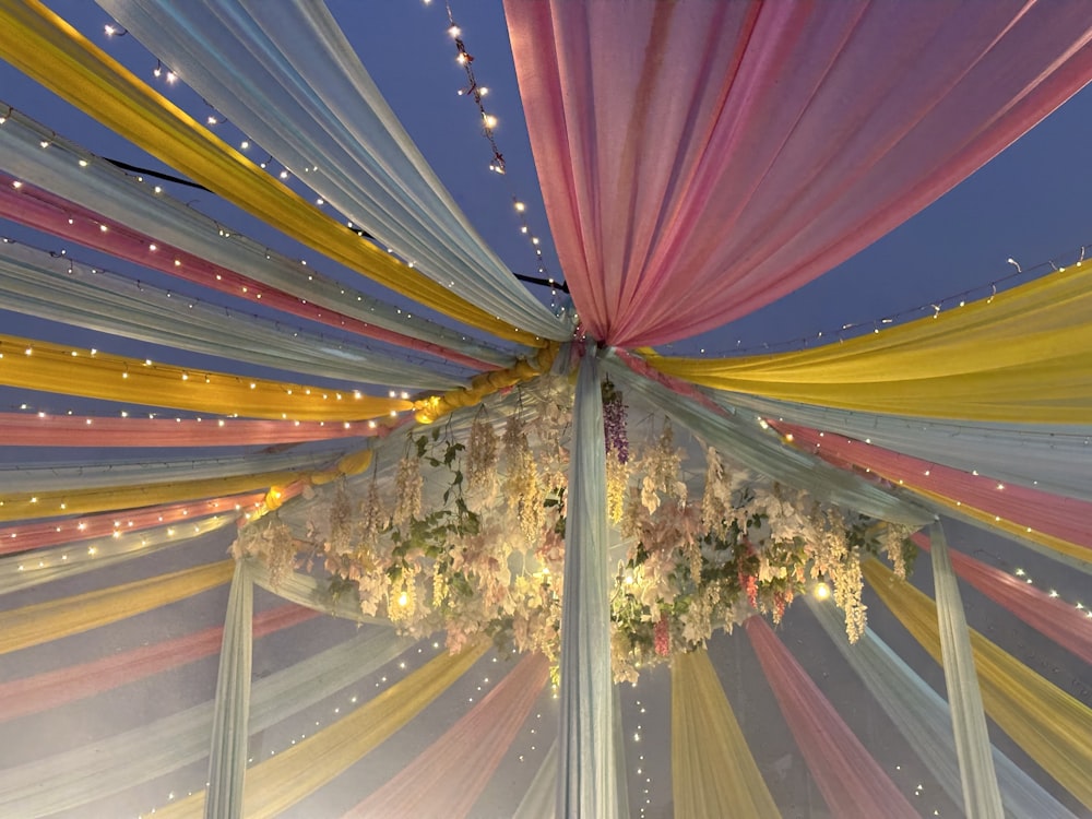 a canopy covered in colorful fabric and flowers