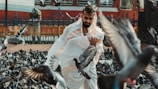 a man in a white outfit surrounded by birds