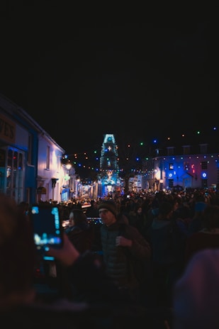 A vibrant photo of a lively village festival at night with colorful lights and joyful people.