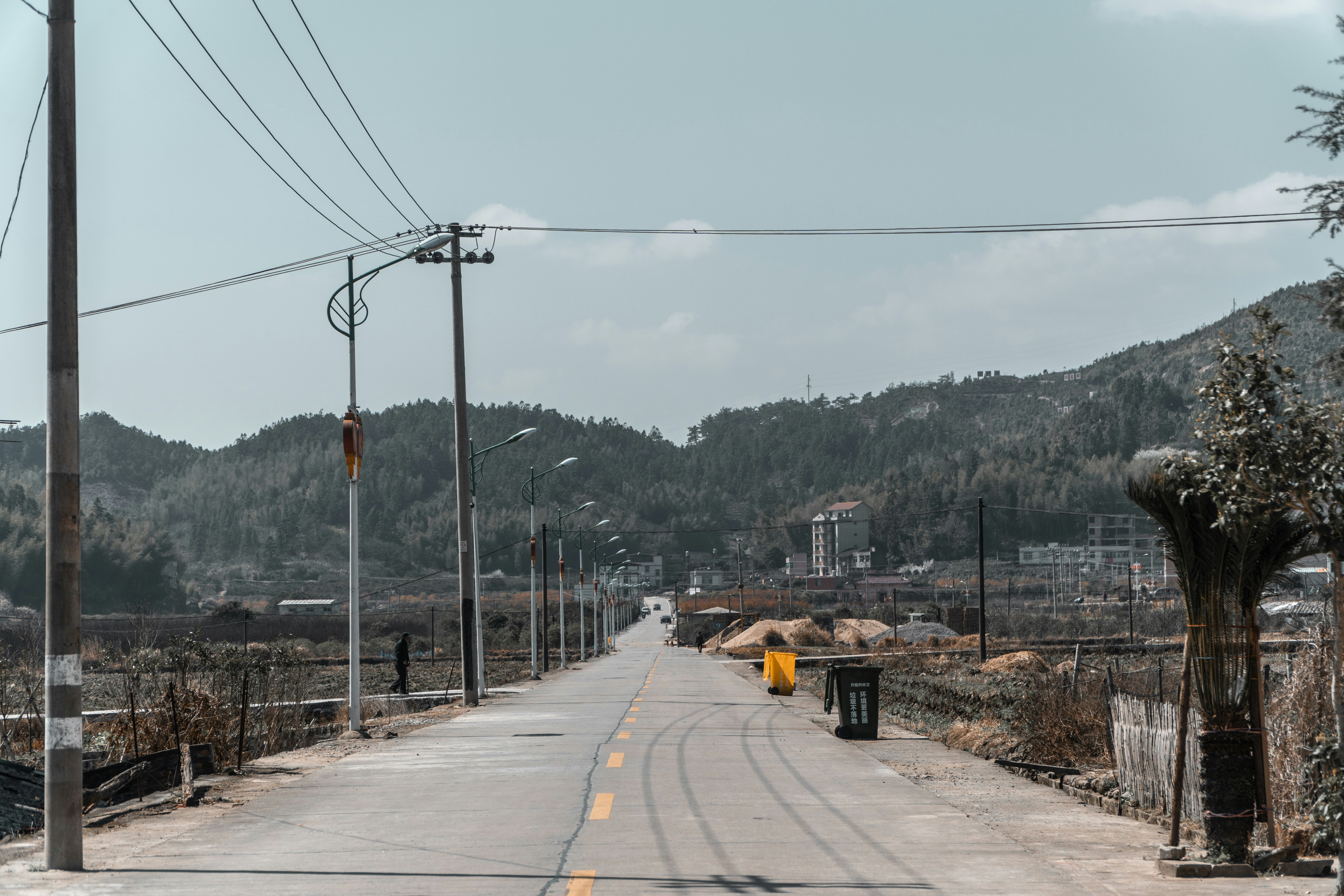 a long empty road with a mountain in the background