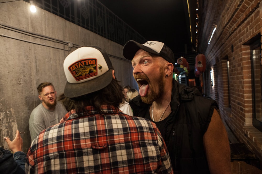 a man sticking his tongue out in a crowded alleyway