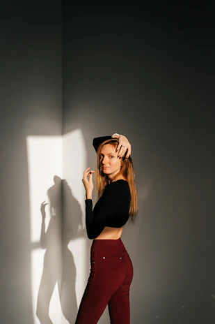 A woman wearing nadra wide-leg black pants standing confidently against a soft off-white background.