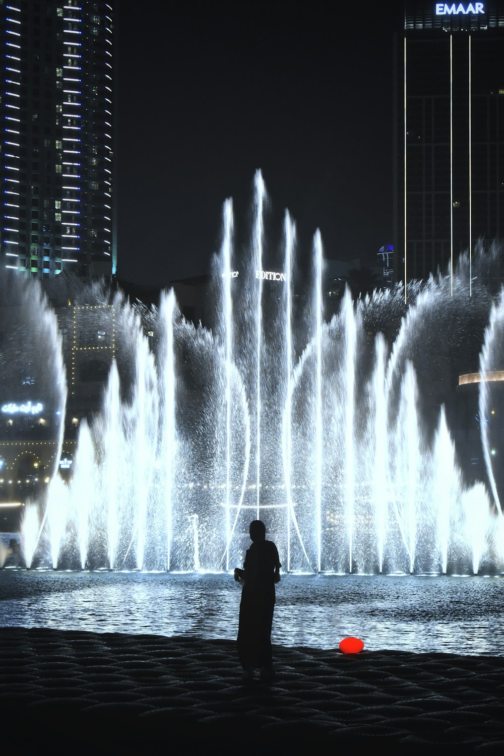 a man standing in front of a fountain of water