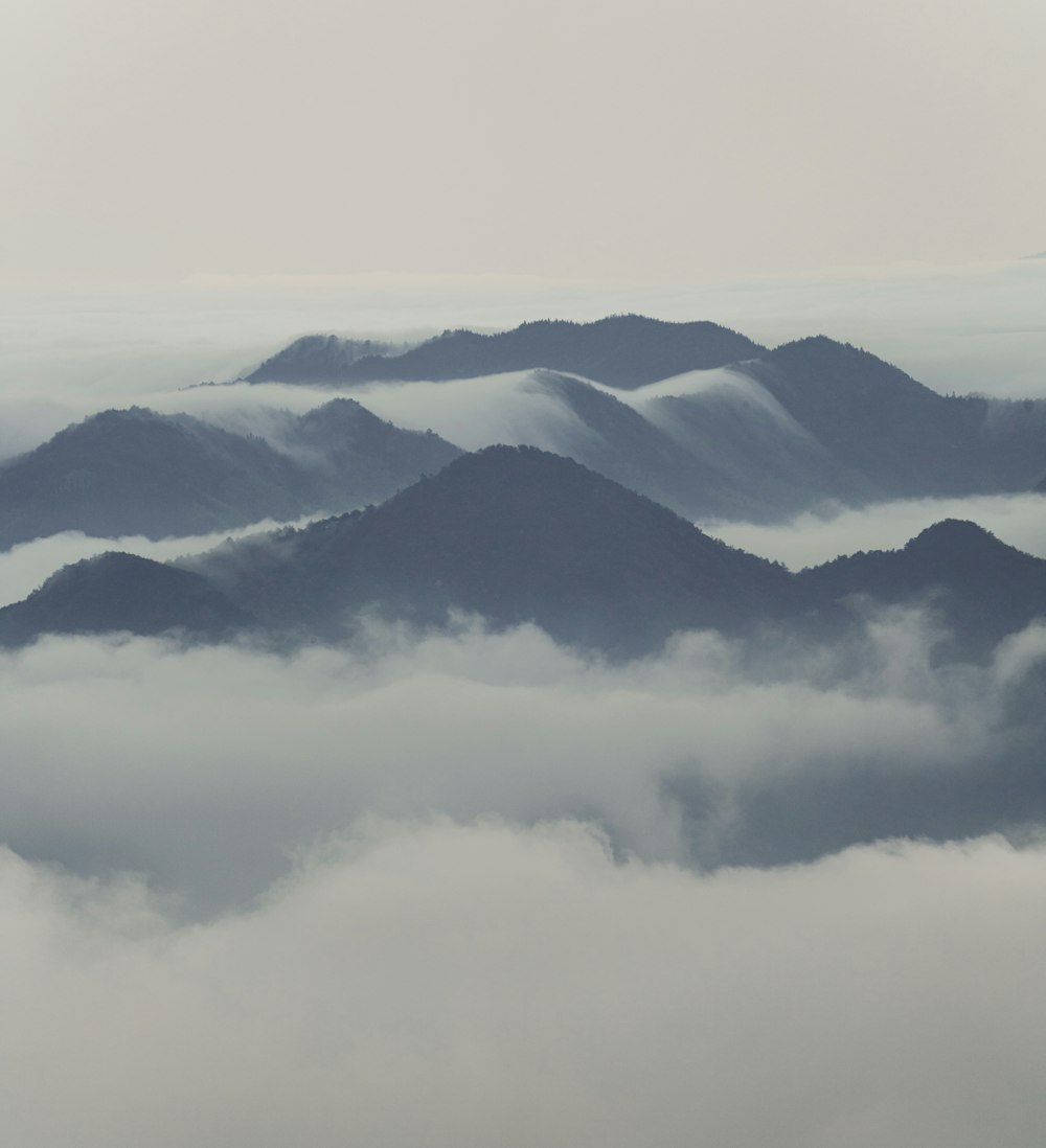 a view of a mountain range covered in clouds