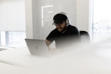 a man wearing headphones and using a laptop