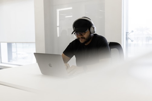 a man wearing headphones and using a laptop