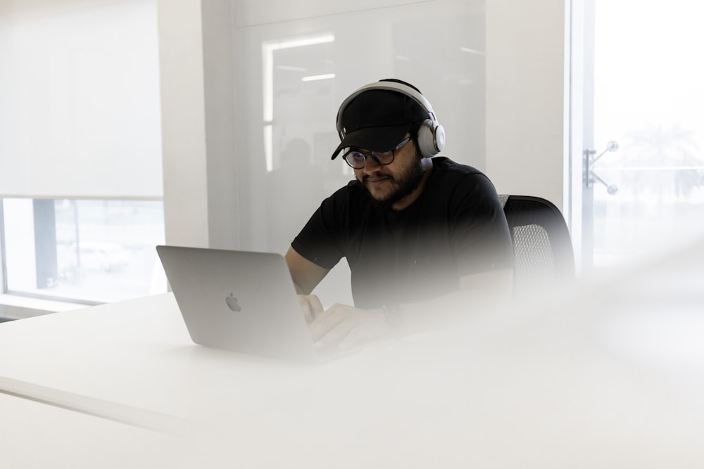 a man wearing headphones and using a laptop