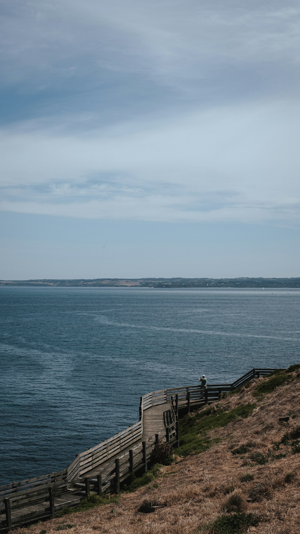 a bench on the side of a hill overlooking the ocean