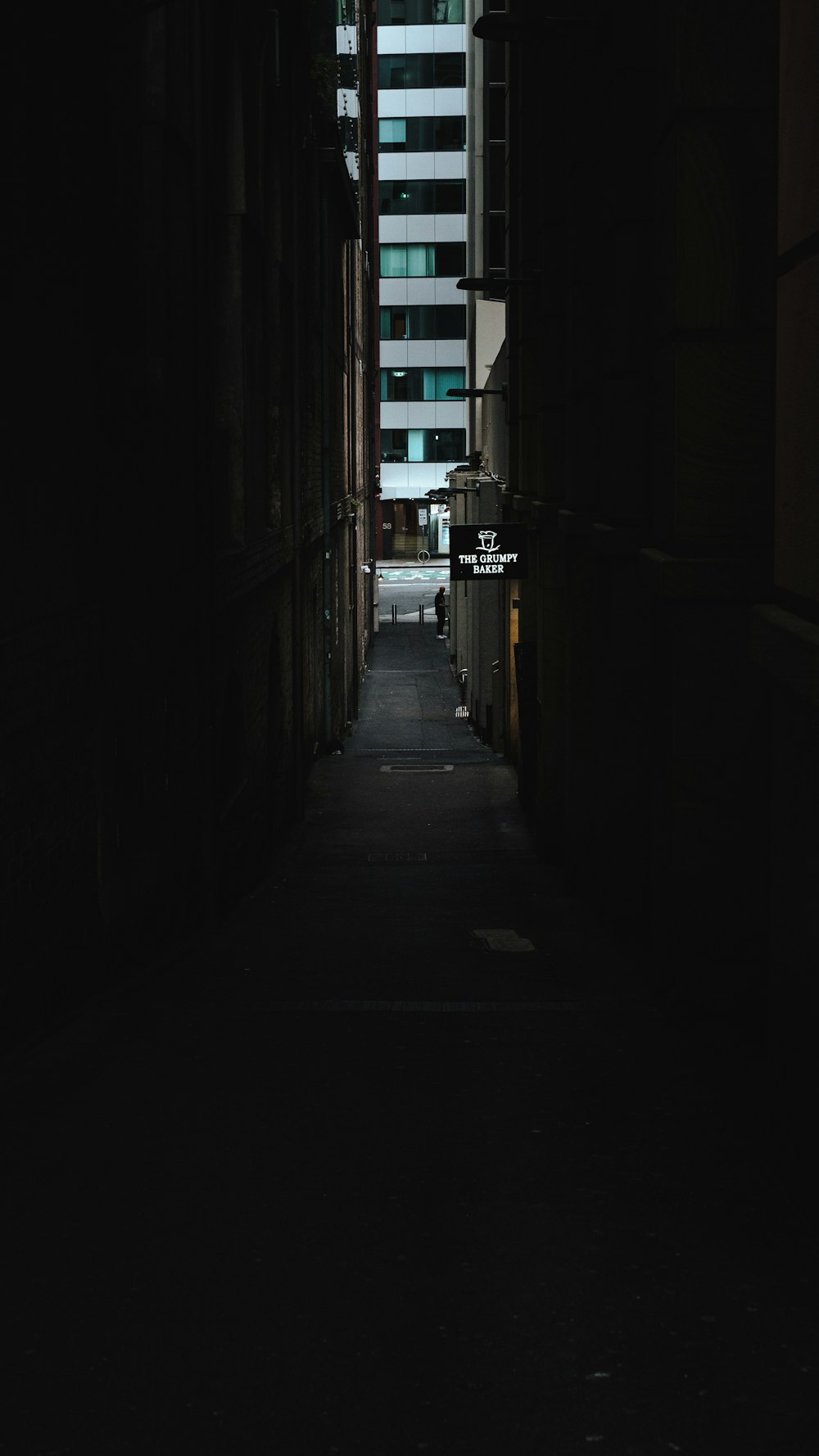 a dark alley way with a building in the background