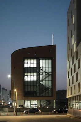 A sleek exterior view of Anand Capitol City Centre at dusk with warm lighting.