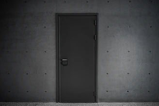 a black door is open in a dark room