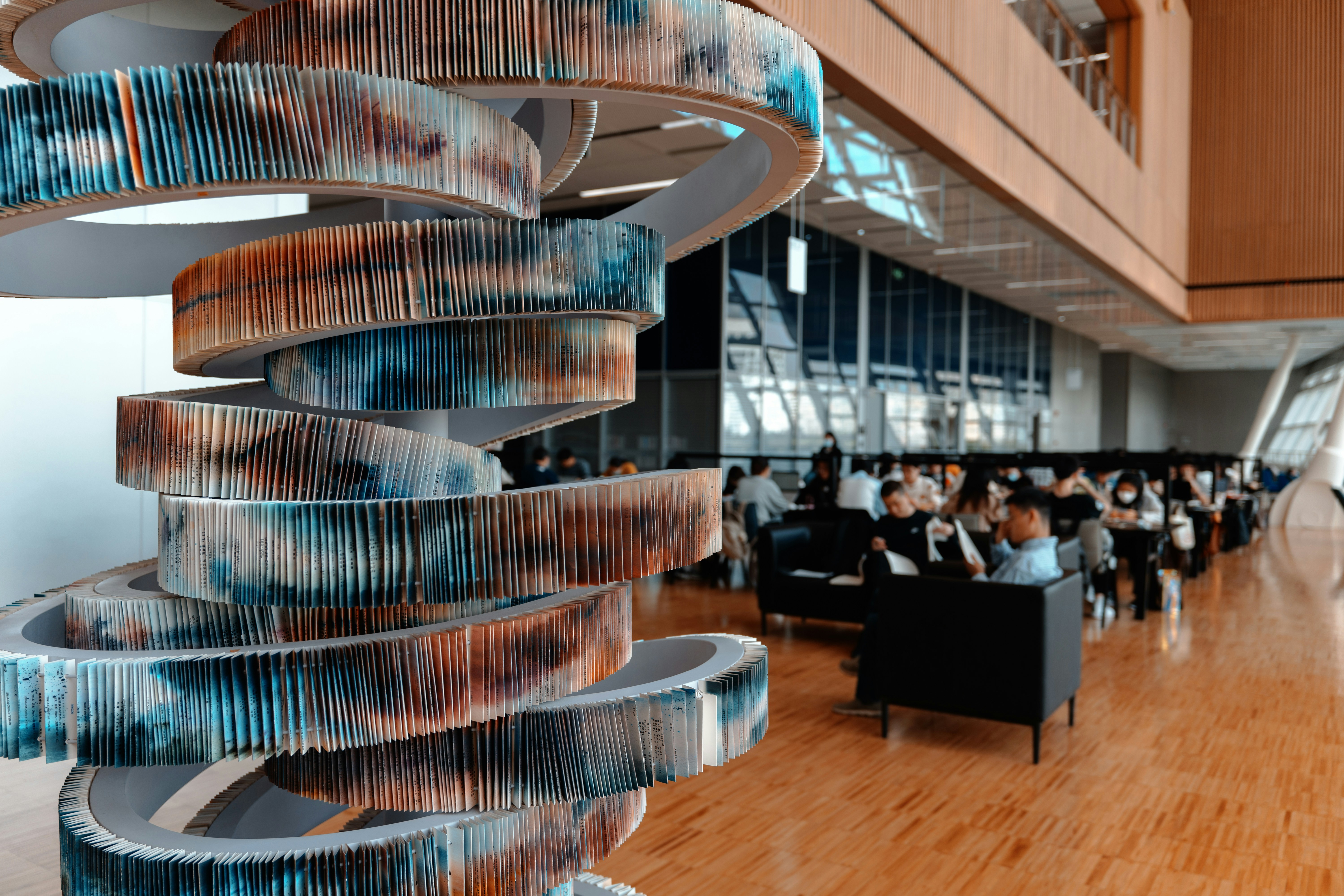 Spiral staircase of books in a busy library