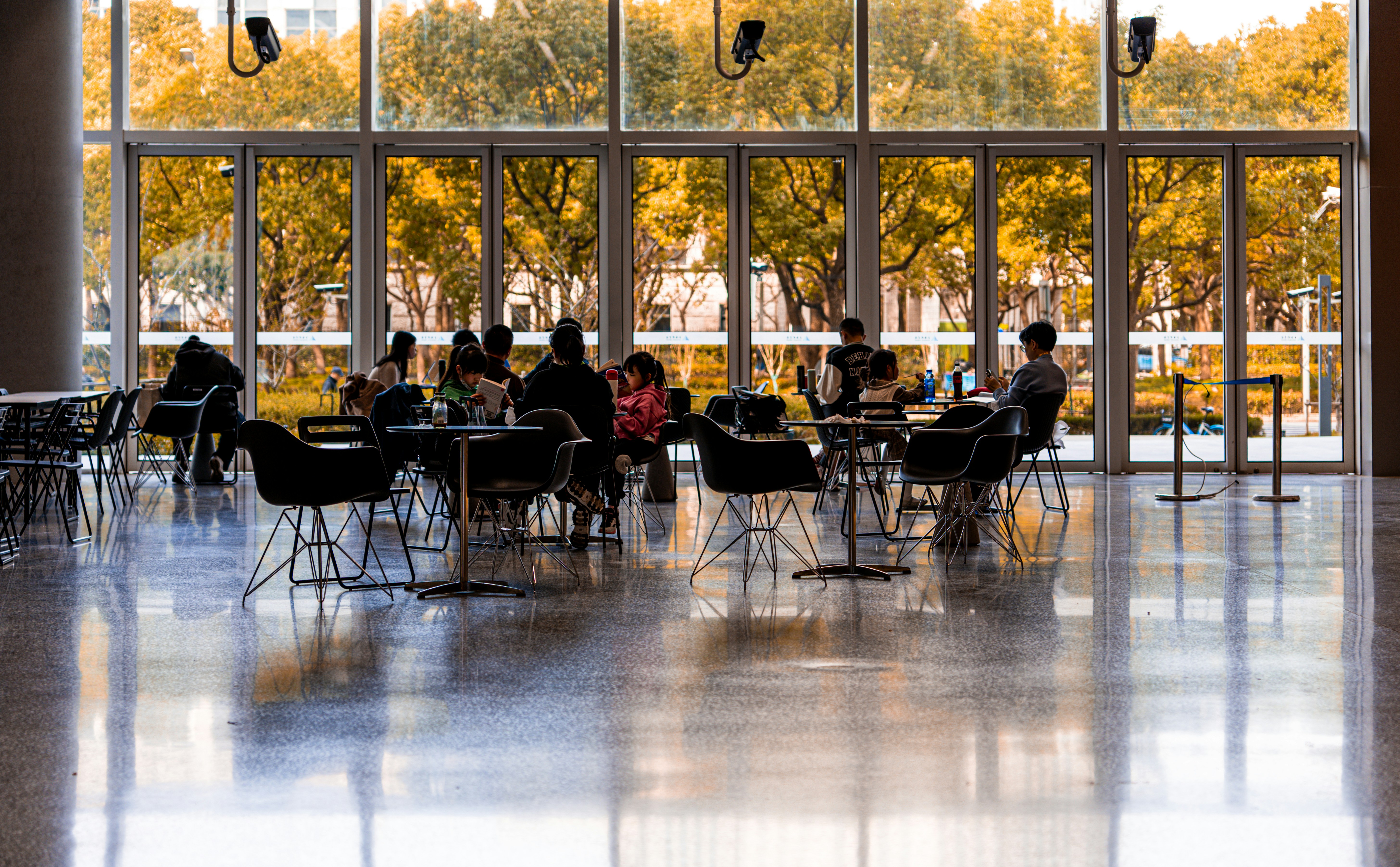 a group of people sitting at tables in front of a window