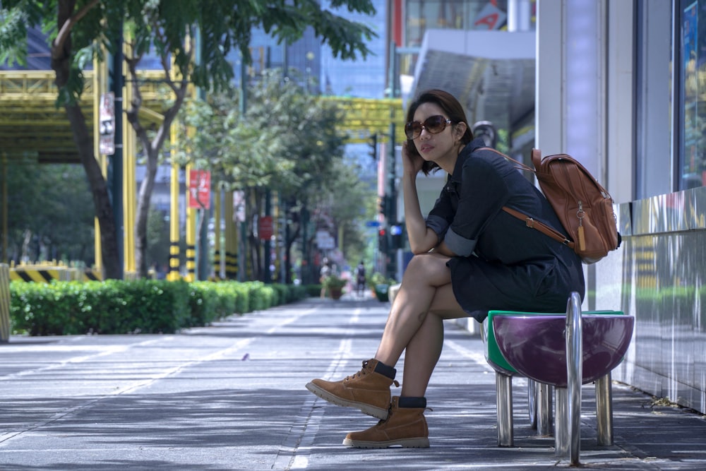 a woman sitting on a chair on a sidewalk