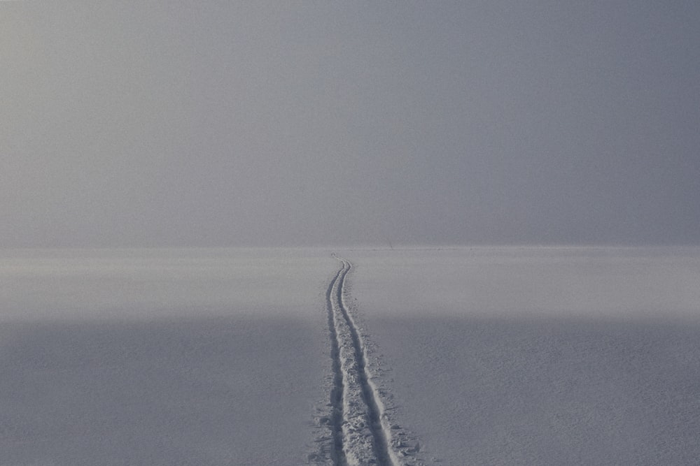 a person riding a snowboard down a snow covered slope