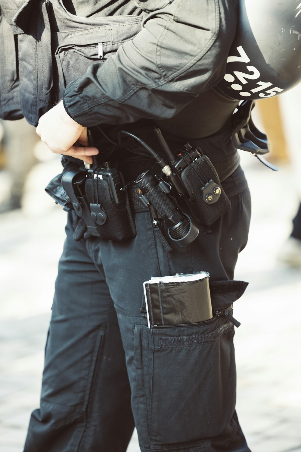 Um policial está segurando uma arma e um capacete