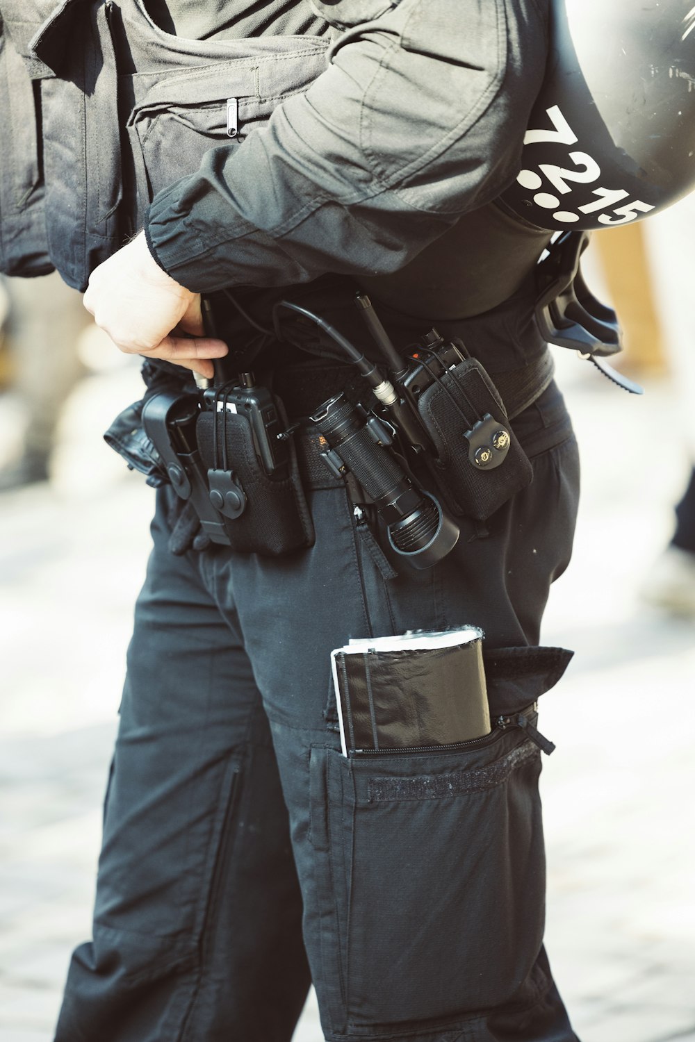 Ein Polizist hält eine Waffe und einen Helm in der Hand