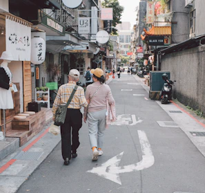 An elderly couple happily exploring a vibrant city.