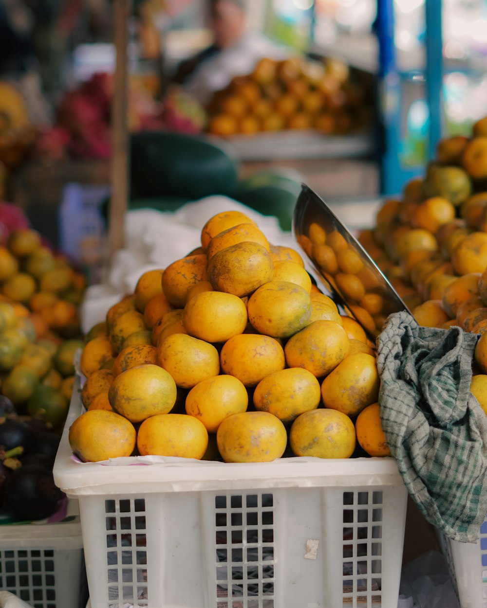 a pile of oranges sitting on top of a white basket