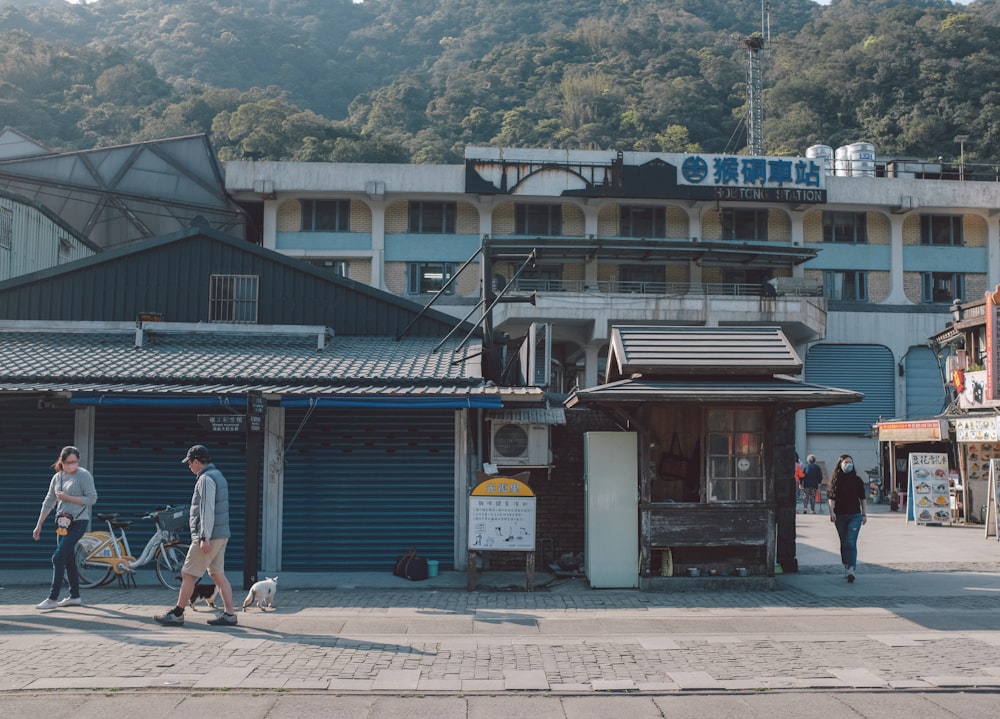 a group of people walking down a street next to a building