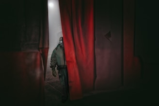 A dramatic scene depicting a scientist in hiding, surrounded by shadows.