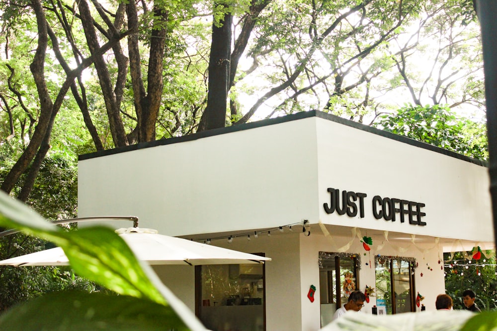 a white building with a sign that says just coffee