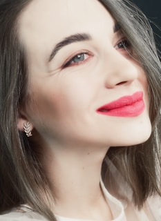 A smiling woman with flawless base makeup and subtle lip color, ready for a small event