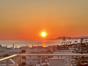 A serene sunset over a peaceful Asian coastal town, symbolizing the promise of a relaxed retirement.