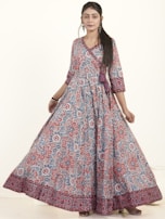 Close-up of a woman wearing a flowing, patterned dress paired with delicate accessories.