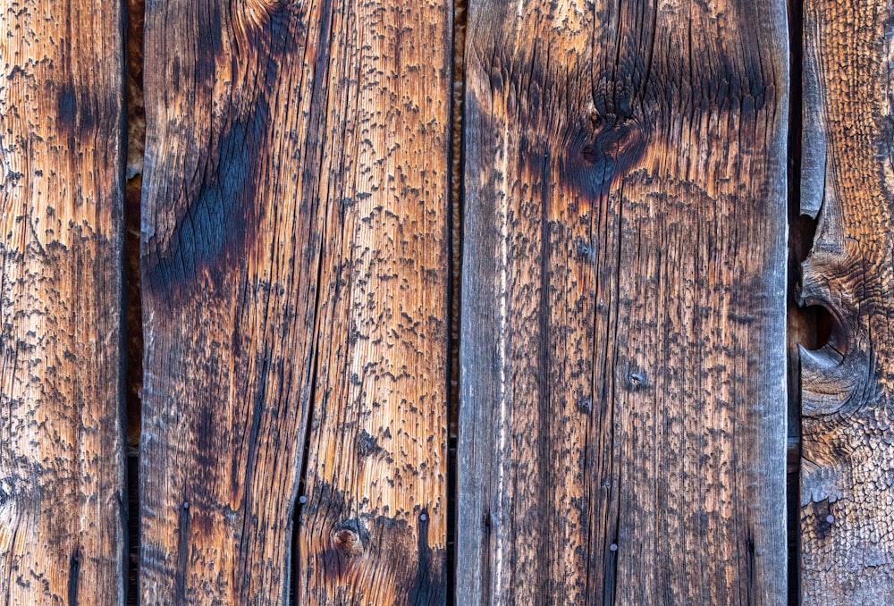 a close up of a wooden wall with peeling paint