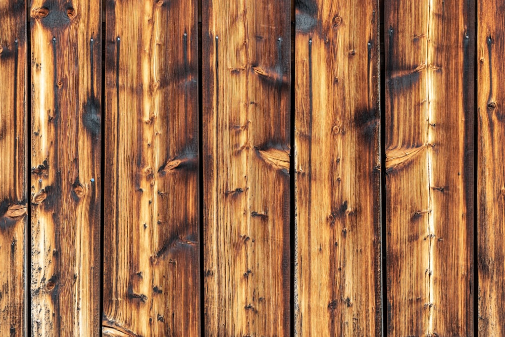 a close up of a wooden fence with knots