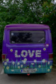 A purple-themed mobile detailing van with the Nicks Noteworthy logo parked in front of a Colo, IA home.