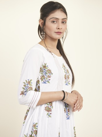 Model posing in a festive lawn outfit with delicate embroidery, set against a clean white background.