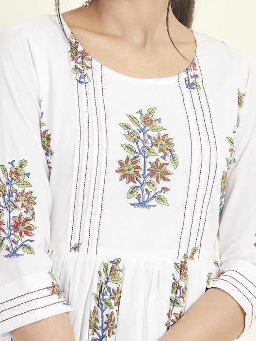 A close-up of intricate hand-embroidered floral patterns on a vibrant traditional Pakistani dress.