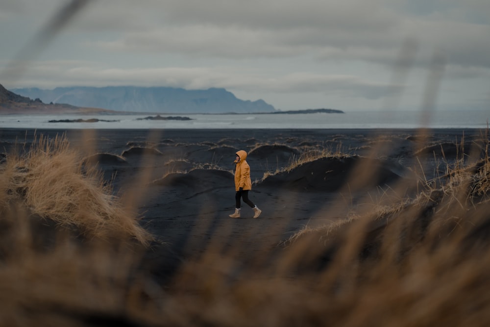 a person in a yellow jacket walking through a field